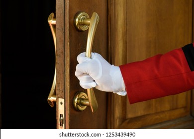 The Doorman Opens The Hotel Door Hands In White Gloves. Welcome