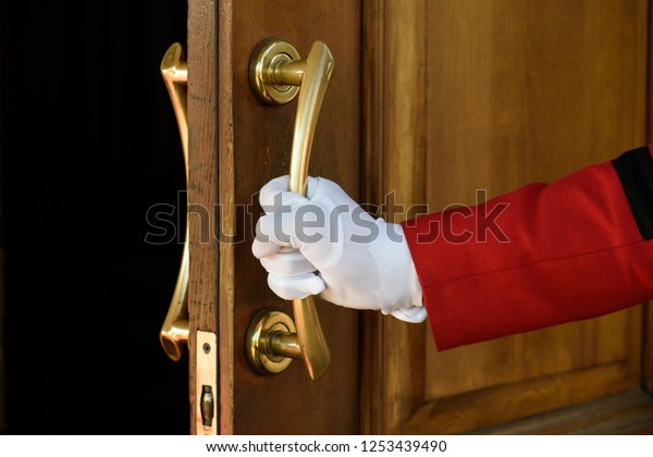 the doorman opens the hotel door hands in white
gloves. Welcome
