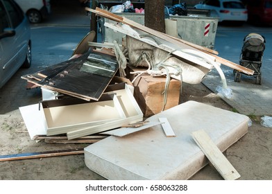 Doors Mattress Bathtub And Baby Stroller Thrown In The Garbage In The City Near Dumpster Can Littering And Polluting Environment With Overflow Junk 