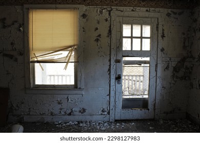 A doorway leading to the backyard from the kitchen in an abandoned home in a ghost abandoned town.