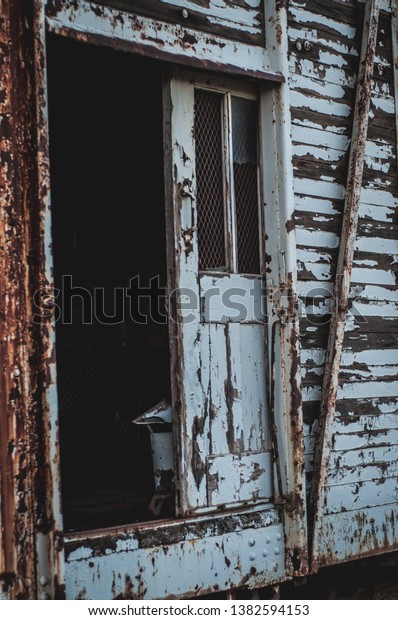 The doorway of an\
old abandoned train car.