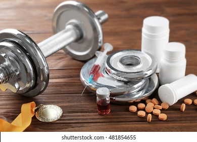 Dope In Sports. Dumbbell, Medal And Drugs On Wooden Background