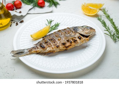 Dorado On Grill On A White Plate On White Concrete Table