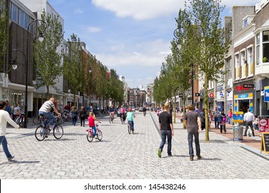 DORDRECHT, NETHERLANDS - JUNE 30: Busy shopping street with people walking and cycling in the sunny historic center on June 30, 2013 in Dordrecht. The new shopping street was opened in June 2013.