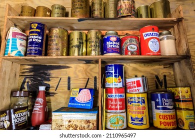 Dorian Bay, Antarctica - 12 10 17: Preserved Antarctic hut interior with historic food supplies and provisions, famous brands and battered old rusty tins and cans, on wooden pantry larder shelves