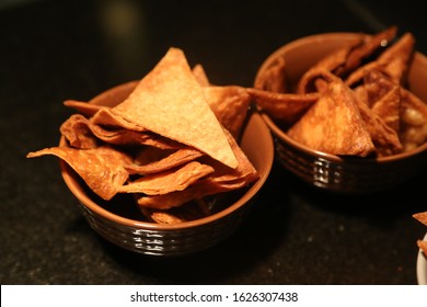 Doritos chips are ready to eat a snack.Chitos in porcelain bowl. doritos in porcelain bowl over black background. crispy snack. spicy triangle chips. 2 chips plates under spot light