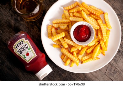 DORKOVO, BULGARIA - JANUARY 16, 2017: Close up on a single bottle of Heinz Tom and french fries over wooden background. Heinz started manufacturing food products in the USA in 1869