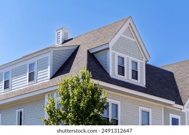 Dormer windows on the sloped shingle roof of a newly built house in Brighton, Massachusetts, USA