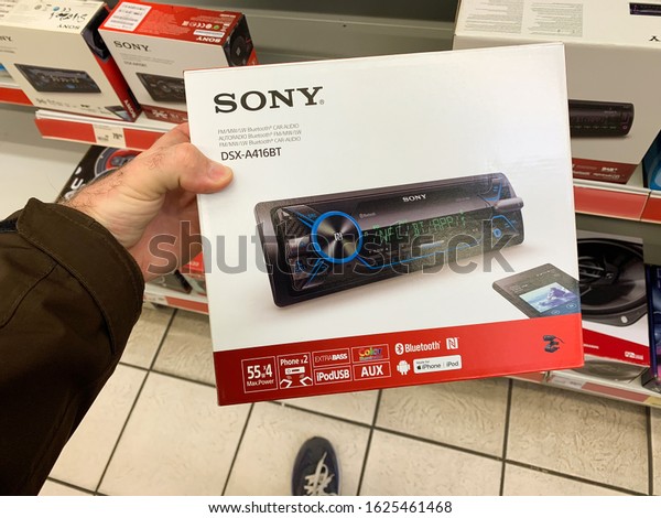 Dortmund,\
Germany - Mar 25, 2019: Man customer hand holding package of new\
auto radio manufactured by SONY modern DSX-A416BT with Bluetooth\
ipod usb connection and DAB digital\
radio