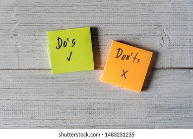 Do's and Don'ts for grammar on two sticky notes on white wooden background.