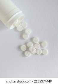 Dose With White Pills On White Background. Overhead View With Copy Space