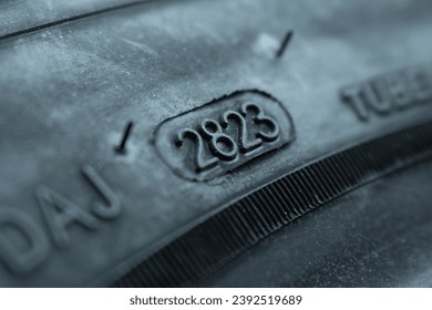 
Dot code and date of production of the tire on the sidewall of the wheel. Close up. Tire shelf life.