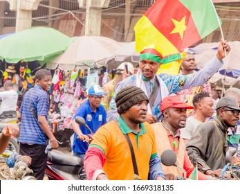 Douala, Littoral/ Cameroon - february 08, 2020: Man standing on the bike with the Cameroon flag in the streets of Douala to protest against election fraud and misgovernance in Cameroon.