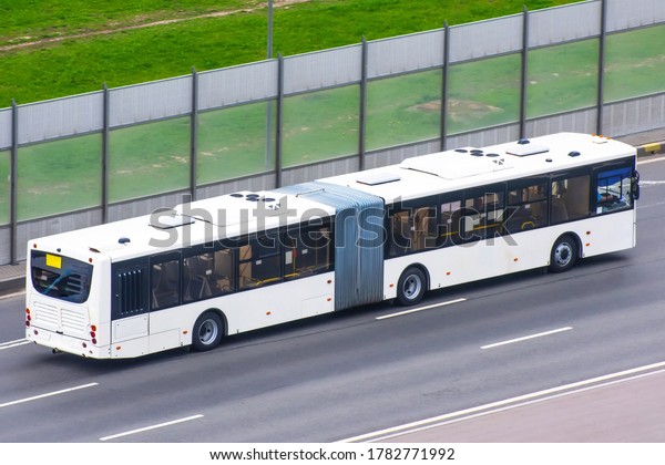 Double\
articulated bus rides on the highway in the\
city.