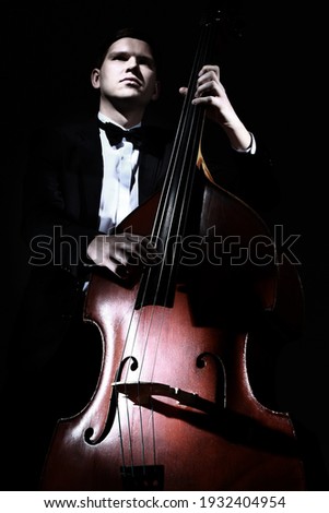 Double bass player contrabass playing. Jazz musician bassist