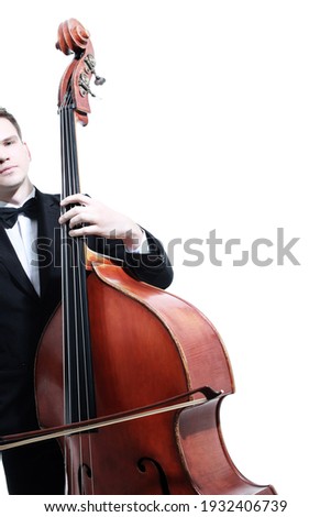 Double bass player playing contrabass with bow. Classical musician close up