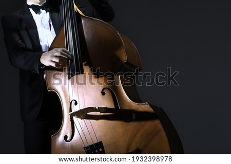 Double bass strings. Hands playing contrabass player. String musical instrument.