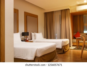 Double bed in the modern interior room with two white pillows and white bath towels