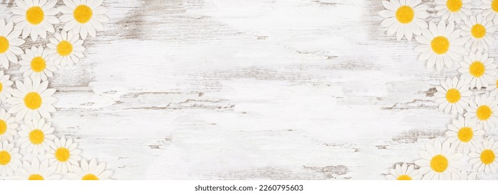 Double border of white daisy flower paper decorations. Top view over a rustic white wood banner background. Copy space. - Powered by Shutterstock