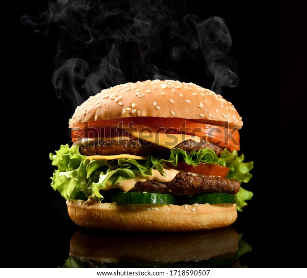 Double burger cheeseburger barbeque sandwich\
with beef  cheese and fresh vegetables hot with steam smoke on\
black background with free text space\
banner