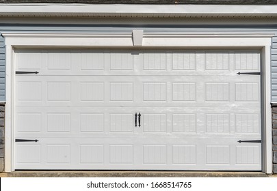 Double Car Classic Insulated Steel Raised Panel Garage Door Framed With A White Trim To Add Accent,  On A New American Home