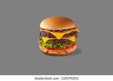 Double Cheeseburger with beef patty, fried onions, lettuce, fresh tomatoes, pickles and paprika sauce. Burger stands on a gray background. - Powered by Shutterstock