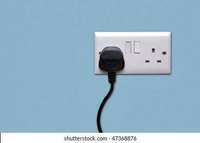 Double Electrical Power Socket And Single Plug Switched On, Blue Background.