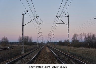Double electrified railway track and beautiful sky at sunset. Industrial landscape. Heavy industry. Railway junction.              