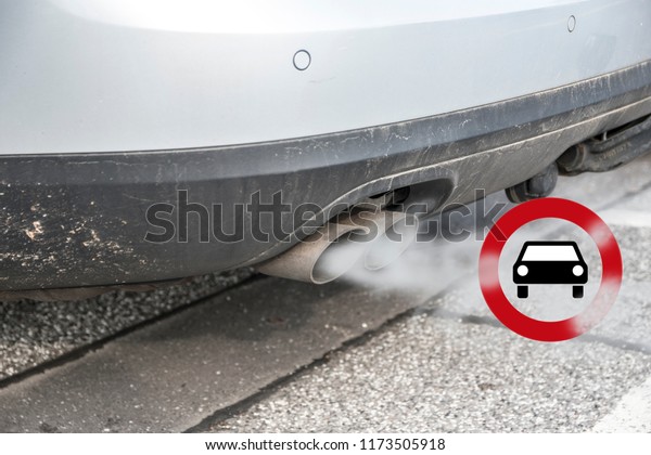 Double\
exhaust from a car with smoke and the traffic sign for driving ban,\
in german Fahrverbot for diesel motor vehicles in low emission\
zones of some cities in Germany, selected\
focus