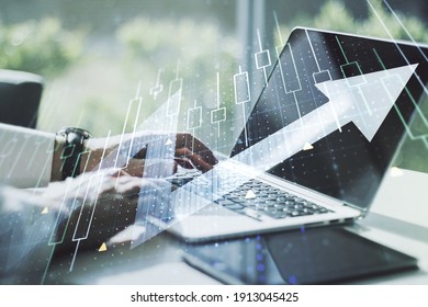 Double exposure of abstract creative financial diagram with upward arrow and hands typing on computer keyboard on background, growth and development concept