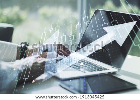 Double exposure of abstract creative financial diagram with upward arrow and hands typing on computer keyboard on background, growth and development concept