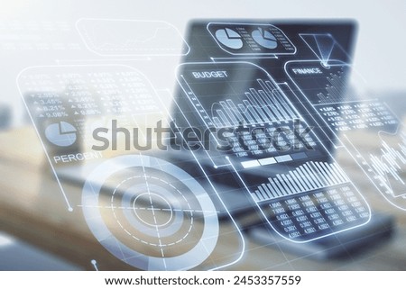 Double exposure of abstract creative statistics data hologram and modern desktop with laptop on background, statistics and analytics concept