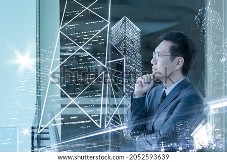 Double exposure of asian businessman and city with high rise skyscrapers.