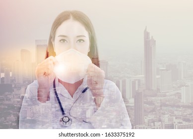 Double Exposure Of Asian Woman Doctor Holding A Mask With Buildings In The Big City Background, Concept To Health Care And Primary Disease Prevention, Such As PM 2.5 And Coronavirus