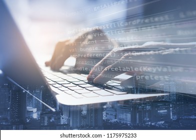 Double exposure business man working on laptop computer and the city. Software developer, programmer coding internet mobile app, modern technology, smart business, internet of things IoT concept.