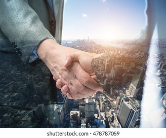 Double exposure of a business people shaking their hands in front of a big city