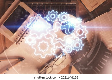 Double Exposure Of Business Theme Hologram Over Desktop With Phone. Top View. Mobile International Trade Connection Concept.