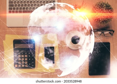 Double Exposure Of Business Theme Hologram Over Desktop With Phone. Top View. Mobile International Trade Connection Concept.