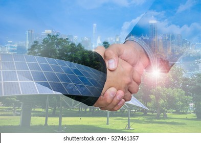 Double Exposure of a businessman handshake on the background blurred downtown nightlife. Concept of an agreement green energy.