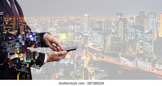 Double Exposure Businessman Touching On Smartphone Screen With City Overlay