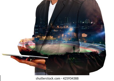 Double exposure of Businessman use Digital Tablet with Sport Stadium at Night