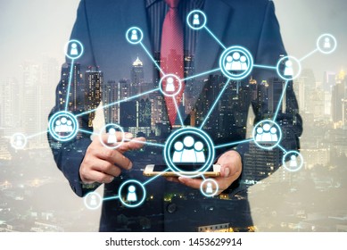 Double Exposure Of Businessman Using Cellphone Or Smart Phone With Organization System And City Night Background, Network Technology Connection Concept