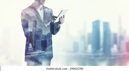 Double exposure of city and business man using digital tablet - Powered by Shutterstock