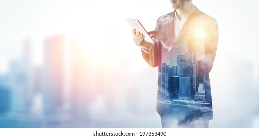 Double Exposure Of City And Business Man Using Digital Tablet 