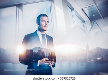 Double exposure of city and businessman using his smartphone