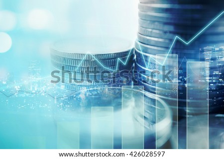 Double exposure of city and graph on rows of coins for finance and banking concept