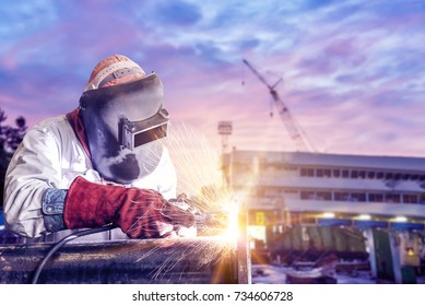 Double Exposure Concept, Worker Steel With By Arc Welder Piping Welding Building In Shipyard Background Soft Monotone