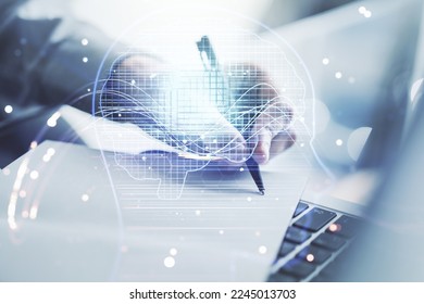 Double exposure of creative artificial Intelligence symbol with hand writing in notebook on background with laptop. Neural networks and machine learning concept