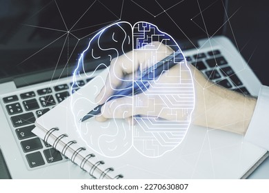 Double exposure of creative artificial Intelligence symbol with hand writing in notebook on background with laptop. Neural networks and machine learning concept