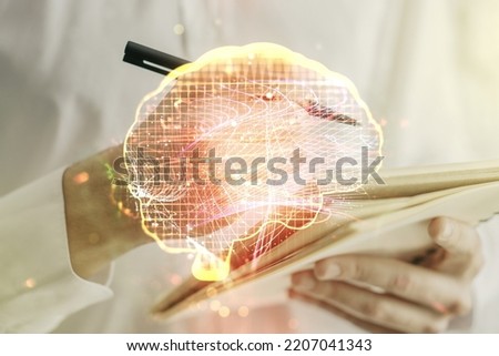 Double exposure of creative artificial Intelligence symbol with man hand writing in notebook on background. Neural networks and machine learning concept